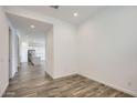 An open floor plan leads to a modern kitchen, enhancing the space with sleek, hardwood floors and contemporary design at 25338 N 150Th Ln, Surprise, AZ 85387
