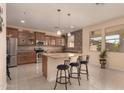 Spacious kitchen with granite countertops, island with seating, and stainless steel appliances at 3443 W Saint Anne Ave, Phoenix, AZ 85041