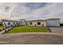 Stunning single-story home with manicured lawn, stone accents, and a three-car garage at 3950 E Augusta Ave, Queen Creek, AZ 85142