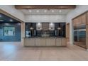 Open-concept kitchen with dark cabinetry, stainless steel appliances, large island, and wood floors at 3950 E Augusta Ave, Queen Creek, AZ 85142