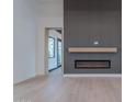 Modern living room featuring an electric fireplace, wood flooring and decorative accent wall at 3950 E Augusta Ave, Queen Creek, AZ 85142
