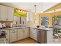 Well-lit kitchen featuring granite countertops, stainless steel dishwasher, and wood-look flooring at 4420 E Amberwood Dr, Phoenix, AZ 85048
