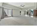 Large living room with carpet and tile flooring, ceiling fan, and sliding glass doors to courtyard at 4525 N 66Th St # 85, Scottsdale, AZ 85251