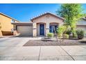 Charming single-story home featuring a manicured front yard, a covered entry, and a two-car garage at 6330 W Constance Way, Laveen, AZ 85339