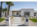 Stylish home exterior with desert landscaping and a walkway leading to the modern, black-framed front door at 7001 E Joan De Arc Ave, Scottsdale, AZ 85254