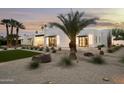 Wide shot of the house exterior with desert landscaping, white brick and black trim modern design at 7001 E Joan De Arc Ave, Scottsdale, AZ 85254