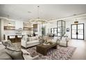 Spacious living room featuring a modern chandelier, sleek kitchen, and open layout perfect for entertaining at 7001 E Joan De Arc Ave, Scottsdale, AZ 85254
