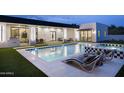 Backyard oasis featuring a sparkling pool, lounge chairs, manicured lawn, and covered outdoor area at 7001 E Joan De Arc Ave, Scottsdale, AZ 85254