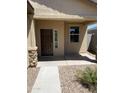 Close up of the front entry way of a tan single-story home with desert landscaping at 7218 E Grouse Ct, San Tan Valley, AZ 85143