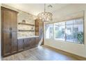 The dining area features a modern chandelier, a large window with backyard view, and built in cabinets at 7438 E Visao Dr, Scottsdale, AZ 85266