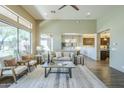 Open living room with high ceilings, large windows, and view into kitchen and back yard at 7438 E Visao Dr, Scottsdale, AZ 85266