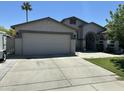Charming single-story home featuring a spacious driveway, two-car garage, desert landscaping and a well-maintained lawn at 9001 W Windsor Ave, Phoenix, AZ 85037