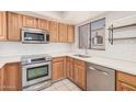Well-lit kitchen featuring stainless steel appliances, light wood cabinetry, and white subway tile backsplash at 9151 W Greenway Rd # 212, Peoria, AZ 85381
