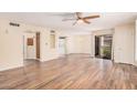 Bright, open-concept living room with wood flooring, ceiling fan, and a view of the balcony at 9151 W Greenway Rd # 212, Peoria, AZ 85381