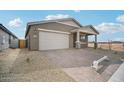 Single-story home featuring a two-car garage and desert landscaping and a fenced side yard at 9533 W Luxton Ln, Tolleson, AZ 85353