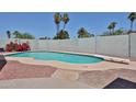 Backyard swimming pool featuring a diving board, red rock landscaping, and mature palm trees at 9851 N 28Th Way, Phoenix, AZ 85028