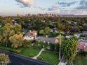 Expansive aerial view of the charming home, lush greenery, and a stunning city skyline backdrop at 1015 W Encanto Blvd, Phoenix, AZ 85007