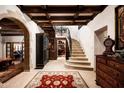 Grand foyer with travertine flooring, arched doorways, and a wrought-iron staircase at 1015 W Encanto Blvd, Phoenix, AZ 85007