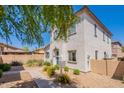 A charming two-story home features a textured white exterior with well-maintained landscaping at 10324 W Sands Dr # 476, Peoria, AZ 85383