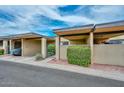 Townhouse exterior featuring covered parking, a secure front gate, and neatly landscaped surroundings at 1146 E Rovey Ave, Phoenix, AZ 85014