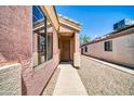 Home exterior showcases the front entrance, a security door, and low maintenance desert landscaping at 12938 W Mandalay Ln, El Mirage, AZ 85335
