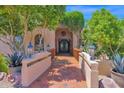 Stunning entryway with an iron gate, tiled pathway, and beautiful landscaping at 1338 W Mountain View Dr, Mesa, AZ 85201