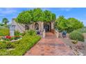 Inviting front entrance featuring lush landscaping and a decorative tile walkway leading to the home's entrance at 1338 W Mountain View Dr, Mesa, AZ 85201