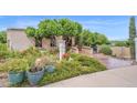 Charming exterior showcasing lush landscaping, decorative planters, and a welcoming walkway to the front door at 1338 W Mountain View Dr, Mesa, AZ 85201