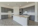 Modern kitchen featuring gray cabinets, white quartz countertops, and stainless steel appliances at 16355 W Desert Mirage Dr, Surprise, AZ 85388