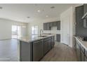 Modern kitchen featuring gray cabinets, white quartz countertops, and stainless steel appliances at 16355 W Desert Mirage Dr, Surprise, AZ 85388