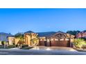 Charming home featuring a beautiful stone facade, three-car garage, and manicured landscaping, showcasing elegance at 16432 S Mountain Stone Trl, Phoenix, AZ 85048