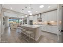 Bright, open kitchen featuring a large island, modern appliances, and seamless flow to living area at 18746 W Rancho Dr, Litchfield Park, AZ 85340