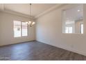 Dining area with tile floors, decorative chandelier and large window overlooking the backyard at 18938 W Ocotillo Rd, Waddell, AZ 85355