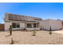 Front exterior of home with solar panels, a two-car garage, and low-maintenance desert landscaping at 19413 N 8Th St, Phoenix, AZ 85024