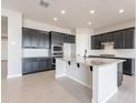 Spacious kitchen features dark cabinetry, granite countertops, stainless appliances and a large island at 20234 W Catalina Dr, Buckeye, AZ 85396