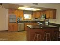Traditional kitchen features wood cabinetry, stainless steel appliances, and a tile backsplash at 2324 W Via Rialto Cir, Mesa, AZ 85202