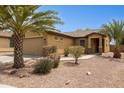 Attractive single-story home with desert landscaping, tile roof, and stone accents around the garage at 25087 W Dove Gap Dr, Buckeye, AZ 85326