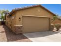 Side view of a two-car garage with stone accents, complementing the home's exterior design at 25087 W Dove Gap Dr, Buckeye, AZ 85326