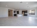 Bright and airy living room features tile flooring, open layout, and seamless flow to the kitchen at 257 S 165Th Ave, Goodyear, AZ 85338