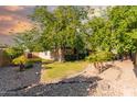 The front yard features lush trees and desert landscaping at 325 E Sharon Ave, Phoenix, AZ 85022