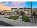 Stunning two-story home with a lush green lawn, stone pathway lighting, and a charming entrance with a 