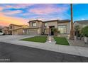 Inviting two-story home featuring a well-maintained lawn, stone accents, and a welcoming entrance with a 