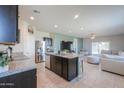 Bright, open kitchen showcasing a granite island with sink and stainless-steel appliances at 36522 W Santa Monica Ave, Maricopa, AZ 85138