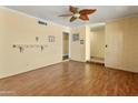 Open living room featuring wood laminate floors, yellow walls, and brick accents at 3836 W Desert Cove Ave, Phoenix, AZ 85029