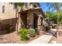Charming two-story home featuring a cozy front porch with stone accents, and lush desert landscaping at 4068 E Devon Dr, Gilbert, AZ 85296