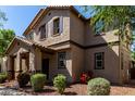 Inviting two-story home featuring a cozy front porch, desert landscaping, and a warm, neutral color palette at 4068 E Devon Dr, Gilbert, AZ 85296
