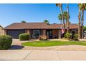 Beautiful brick home with mature landscaping, a lawn, and an American flag displayed at 4418 E Paradise Ln, Phoenix, AZ 85032