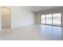 Spacious living area with tile flooring, sliding glass doors to the backyard, and neutral walls at 6728 N 190Th Dr, Waddell, AZ 85355