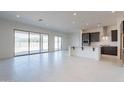 Open floor plan featuring tile flooring, sliding glass doors to the backyard, and a modern kitchen area at 6728 N 190Th Dr, Waddell, AZ 85355