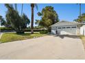 Wide driveway leads to a two-car garage, surrounded by mature trees and manicured landscaping at 6800 E Exeter Blvd, Scottsdale, AZ 85251